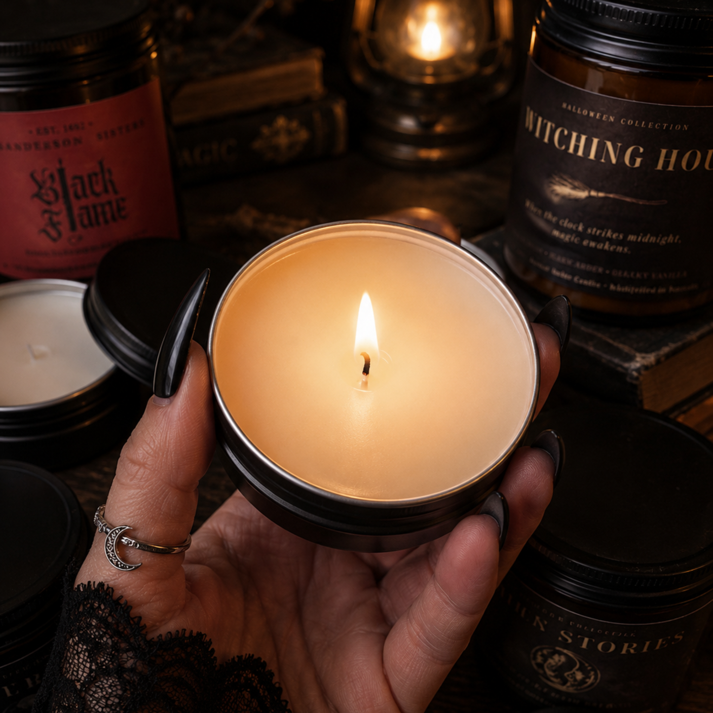 Hand with long black nails holding a lit mini candle from the Forever Amber Candles Halloween Discovery Flight